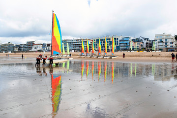 Sailing boat and tourists on a beach in Brittany in summer