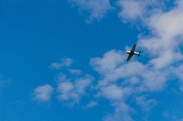 Small airplane flying in the sky with clouds