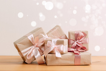 set of beautiful different gift boxes made by handmade with pink bows on a wooden table with a light background. flat lay