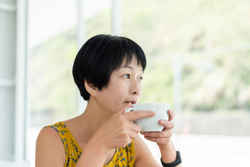 Asian woman hold a cup of coffee