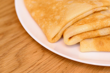 Fragment of three pancakes lying on a plate on the table