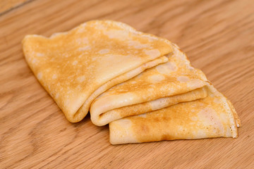 Three pancakes lying on a wooden table