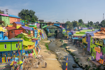 brightly colored facades and roofs of houses in a neighborhood of Malang, Indonesia.