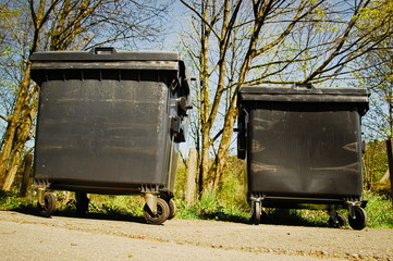 Two dumpsters in the front of a park