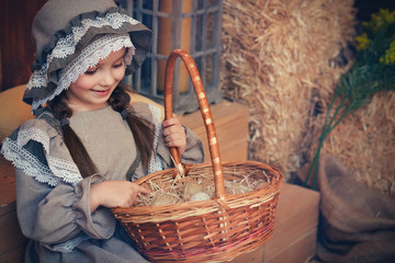 Beautiful girl in an old outfit holds an Easter basket with eggs. Retro picture.
