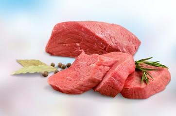 Pieces of fresh meat with pepper and rosemary on a light background