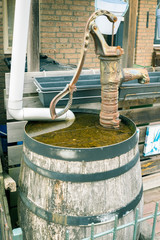 Old water barrel with hand pump