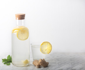 Ginger Water in Glass Bottle With Lemon and Honey on a White Background With Copy Space
