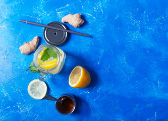 Ginger Water in Glass jar With Lemon and Honey on a Blue Background With Copy Space