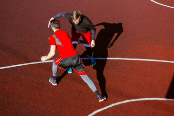 Movement and moment of the dribbling on the basketball court during the match. Athletic lifestyle and basketball competitions. Two young athletes play basketball. Basketball hoop defense and attack.