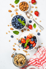 Greek yogurt granola with fresh berries on white table.
