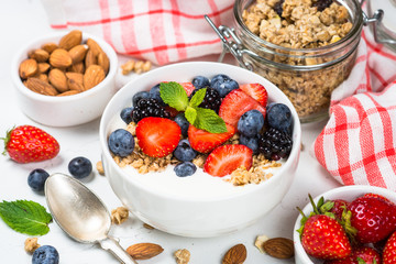 Greek yogurt granola with fresh berries on white table.