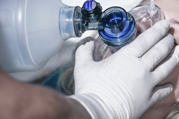 Doctor applying first aid measures using respiratory equipment, artificial lung ventilation, first aid measures