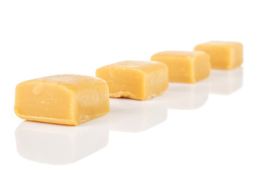 Group of four whole sweet golden caramel candy isolated on white background