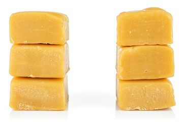 Group of six whole sweet golden caramel candy in two columns isolated on white background