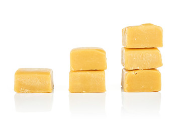 Group of six whole sweet golden caramel candy in three columns isolated on white background
