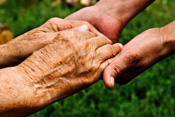 Old hands of a grandmother and a small child close-up