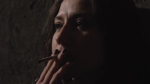 Pensive Depressed beautiful woman smoking cigarette, thinking about her life 