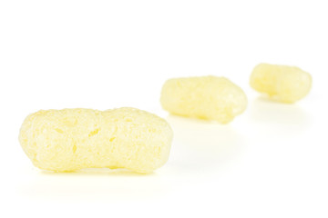 Group of three whole salted yellow corn puff placed diagonally isolated on white background