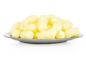 Lot of whole salted yellow corn puff on gray ceramic plate isolated on white background