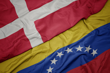 Fototapeta premium waving colorful flag of venezuela and national flag of denmark.