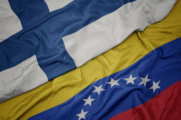 Fototapeta premium waving colorful flag of venezuela and national flag of finland.
