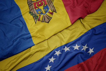 waving colorful flag of venezuela and national flag of moldova.