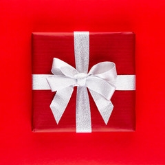 Christmas holiday present box on red background.
