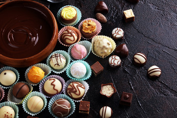 a lot of variety chocolate pralines, belgian confectionery gourmet chocolate on rustic dark background