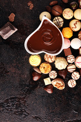 a lot of variety chocolate pralines, belgian confectionery gourmet chocolate on rustic dark background