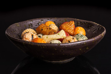 Lot of whole rice japan assortment in dark ceramic bowl isolated on black glass