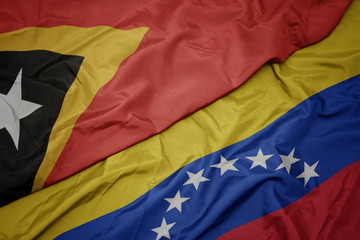 waving colorful flag of venezuela and national flag of east timor.