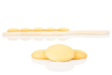 Group of eight whole sweet golden sponge biscuit on small wooden cutting board isolated on white background