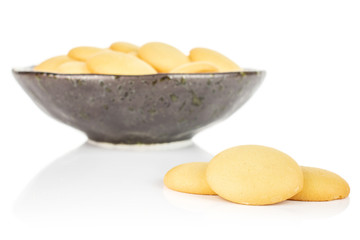 Lot of whole sweet golden sponge biscuit three are aside and the rest is in dark ceramic bowl isolated on white background