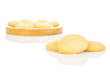 Group of ten whole sweet golden sponge biscuit on bamboo coaster isolated on white background
