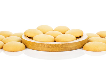 Lot of whole sweet golden sponge biscuit on bamboo coaster isolated on white background