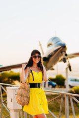 Obraz premium Stylish girl in a yellow dress posing on a plane background.