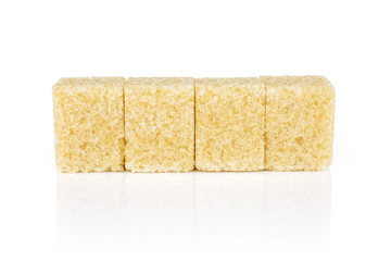 Group of four whole sweet brown sugar cube isolated on white background