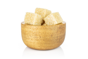 Lot of whole sweet brown sugar cube in tiny wooden bowl isolated on white background