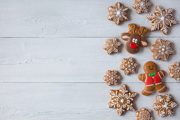 Christmas wooden background with gingerbread snowflakes, gingerbread men and reindeer