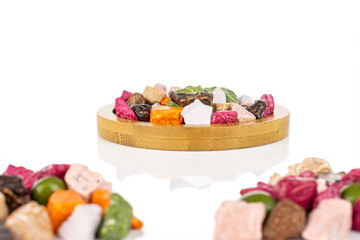 Lot of whole sweet chocolate stone two small groups are in the front and the rest is on bamboo coaster isolated on white background