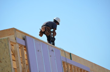 construction worker on wall frame of new house