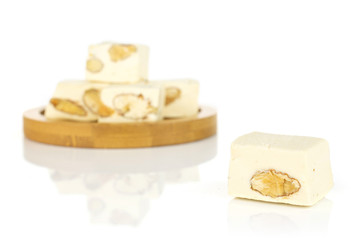 Group of five whole sweet white nougat on bamboo coaster isolated on white background