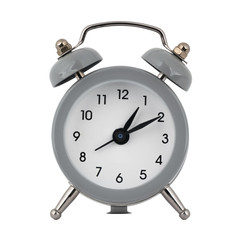 A gray clock with an alarm clock on a white background with arrows showing the time one hour ten minutes or thirteen hours ten minutes