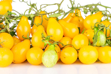 Lot of whole fresh yellow pear tomato on branch isolated on white background