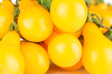 Lot of whole fresh yellow pear tomato in closeup isolated on white background