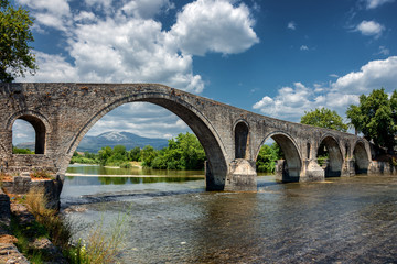 The historic stone bridge of Arta at the banks of Arachthos river in Epirus Greece on a summer day (west view)