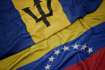 waving colorful flag of venezuela and national flag of barbados.