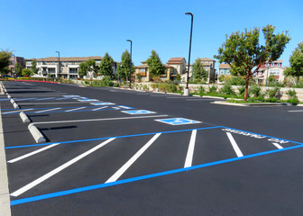 Freshly resurfaced and repainted handicap parking space in a parking lot. The number of handicap...