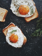 toast with fried eggs on a dark background